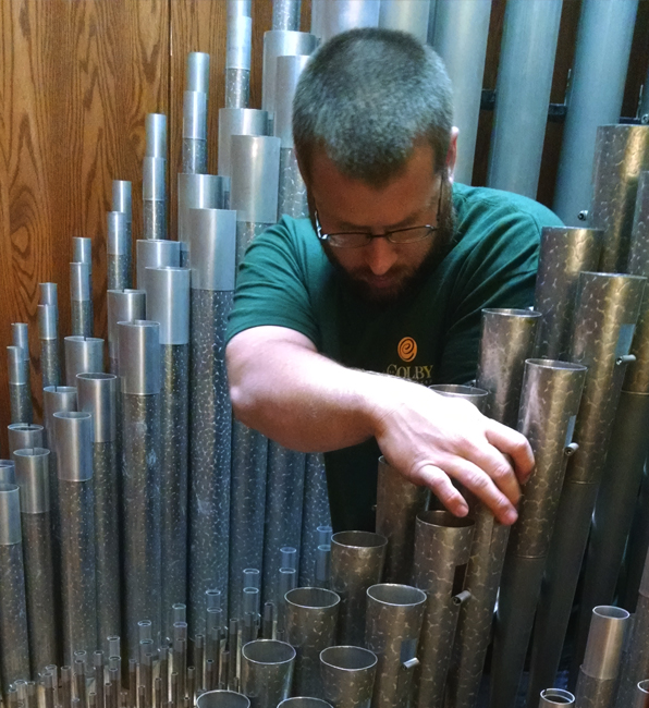 Man performing tuning service on a musical instrument